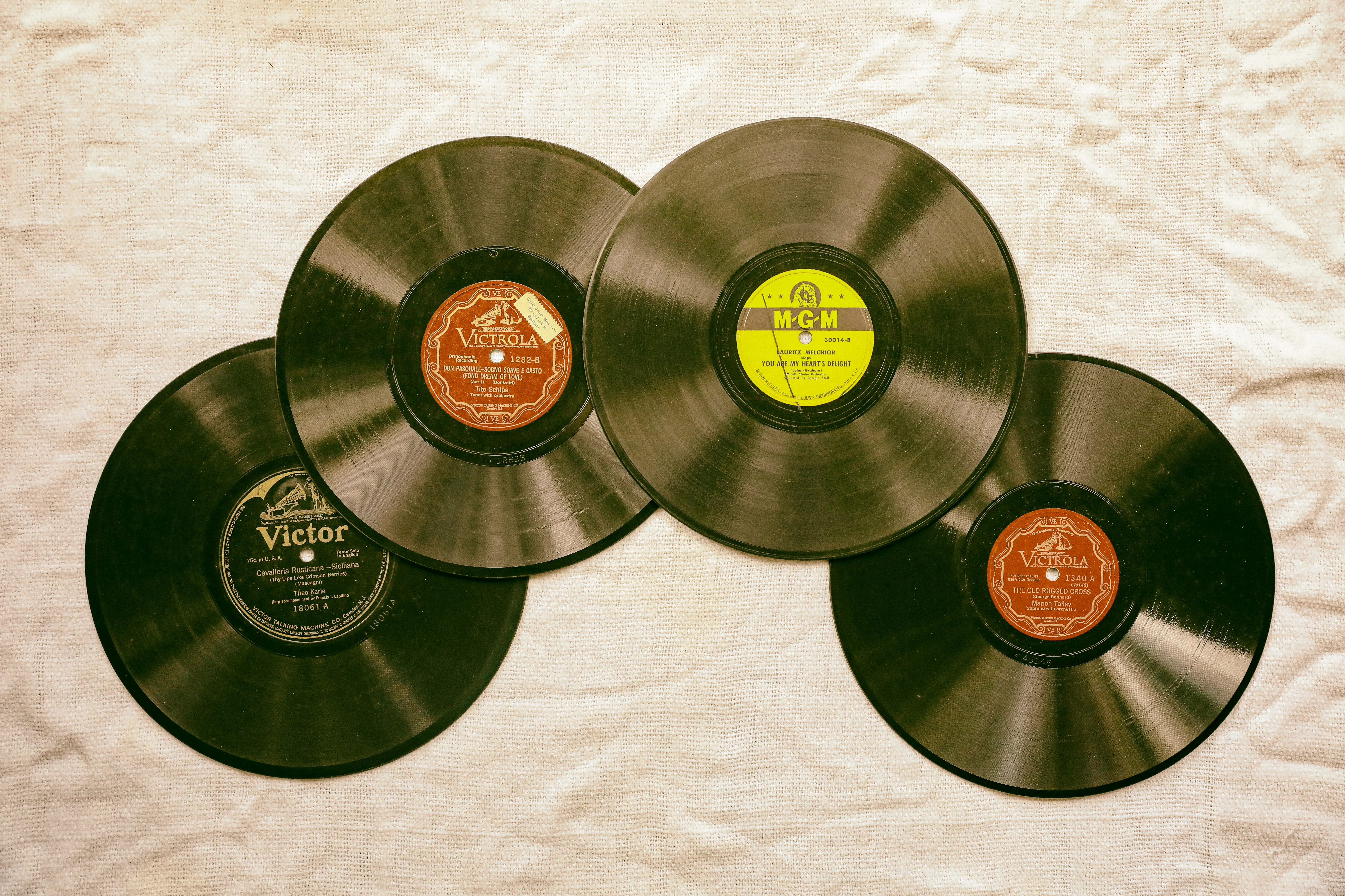 Four LP Vinyl records on a light brown surface.