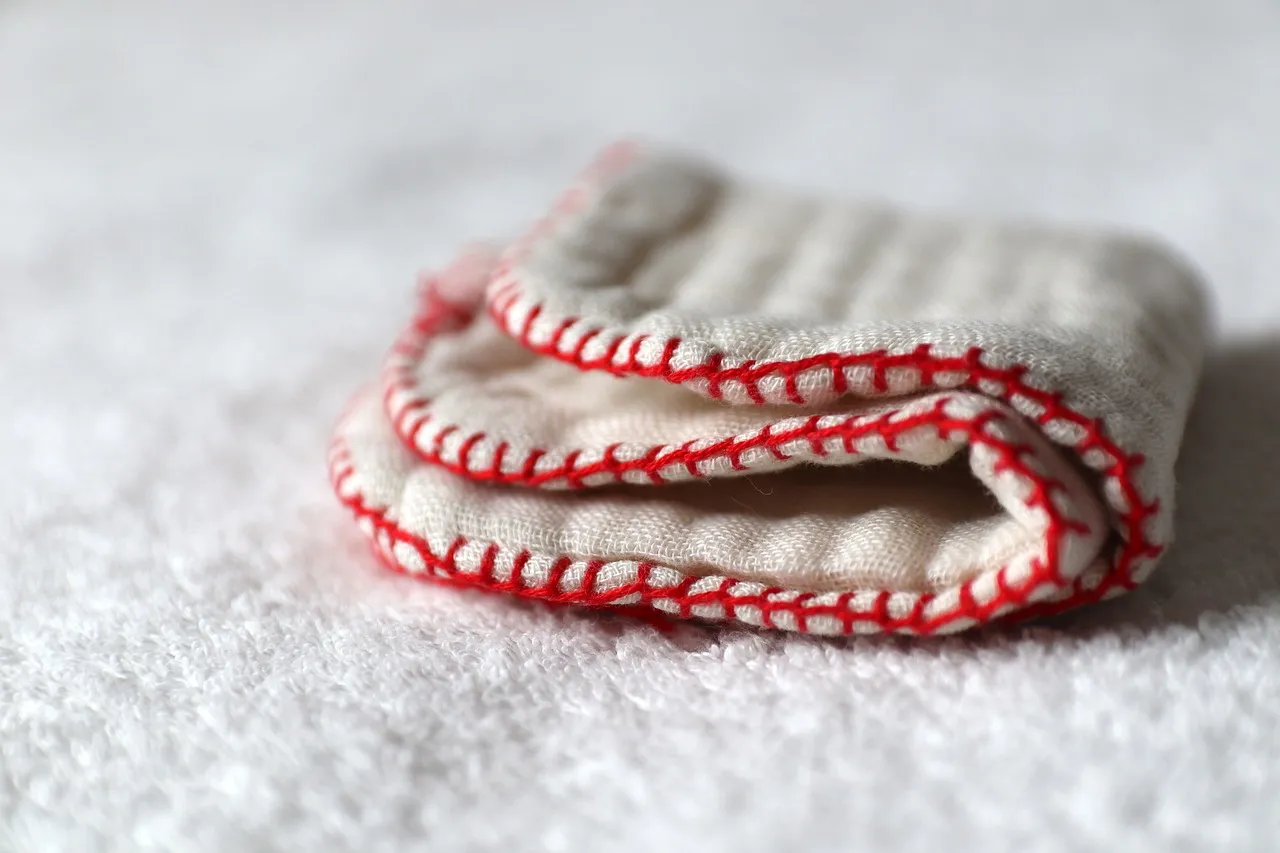 A white homemade handkerchief is placed on a white carpet.