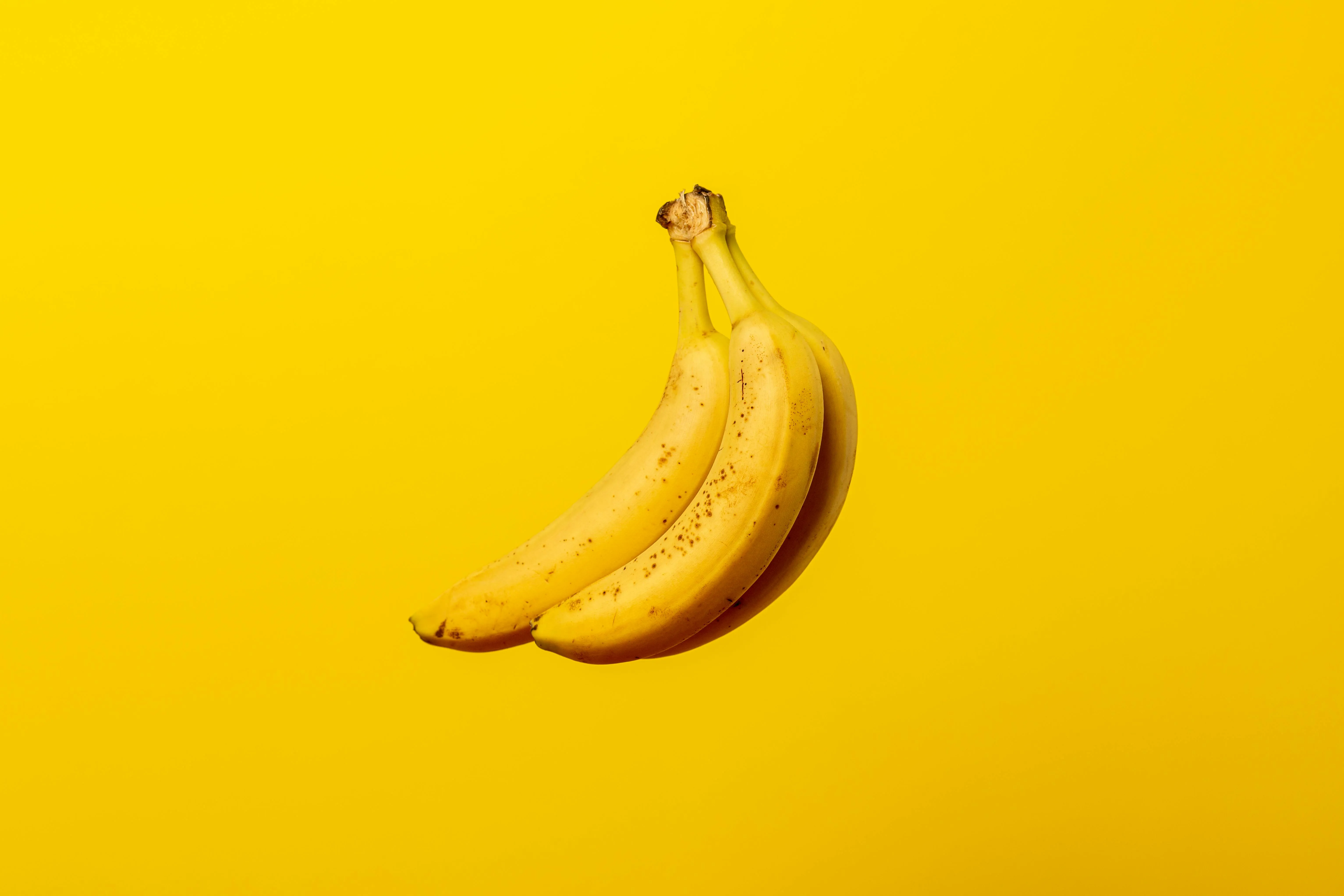 Three banans on a yellow background