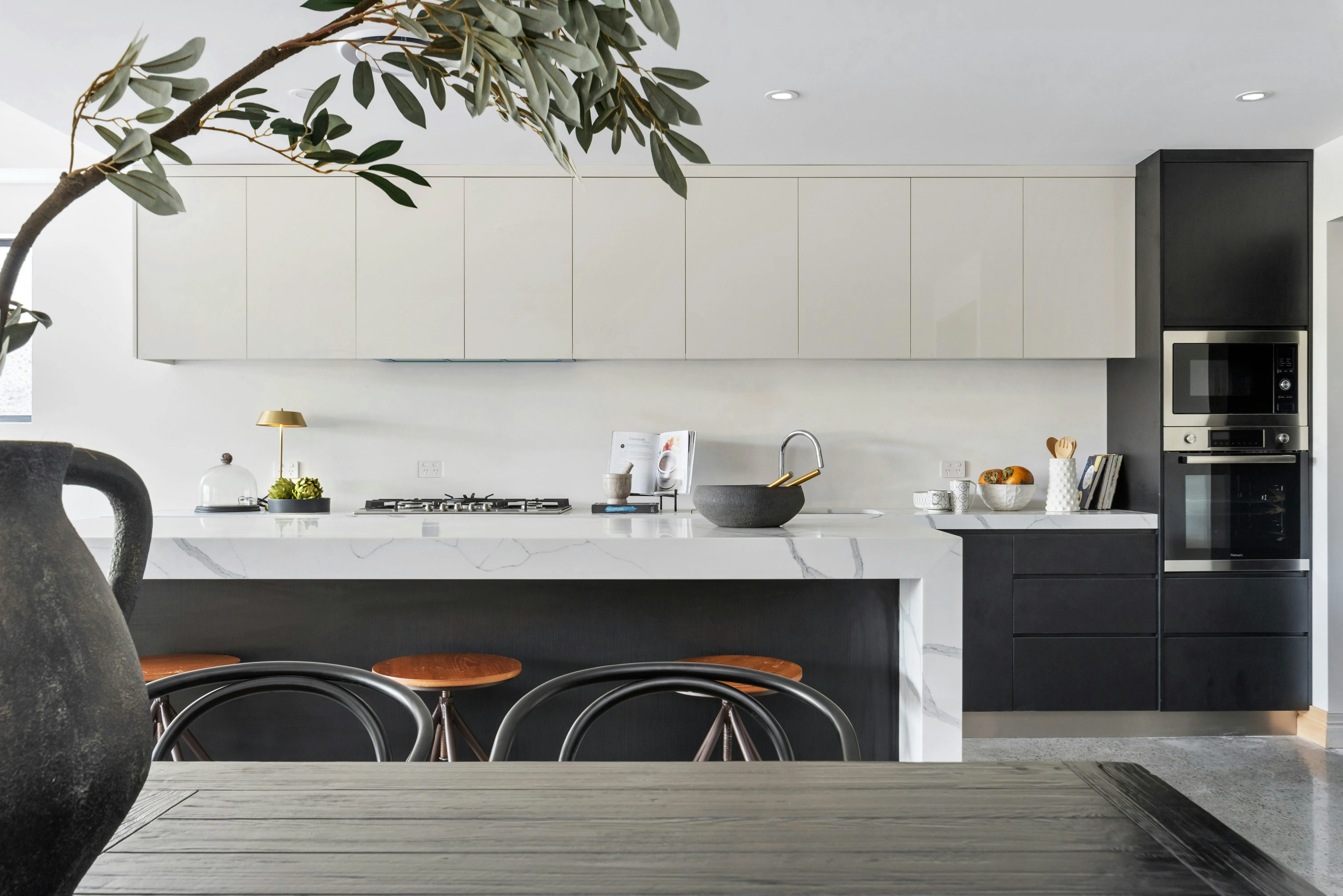 A class black and white dining room color scheme. A white cabinet can be seen along with some tools and chairs for seating.