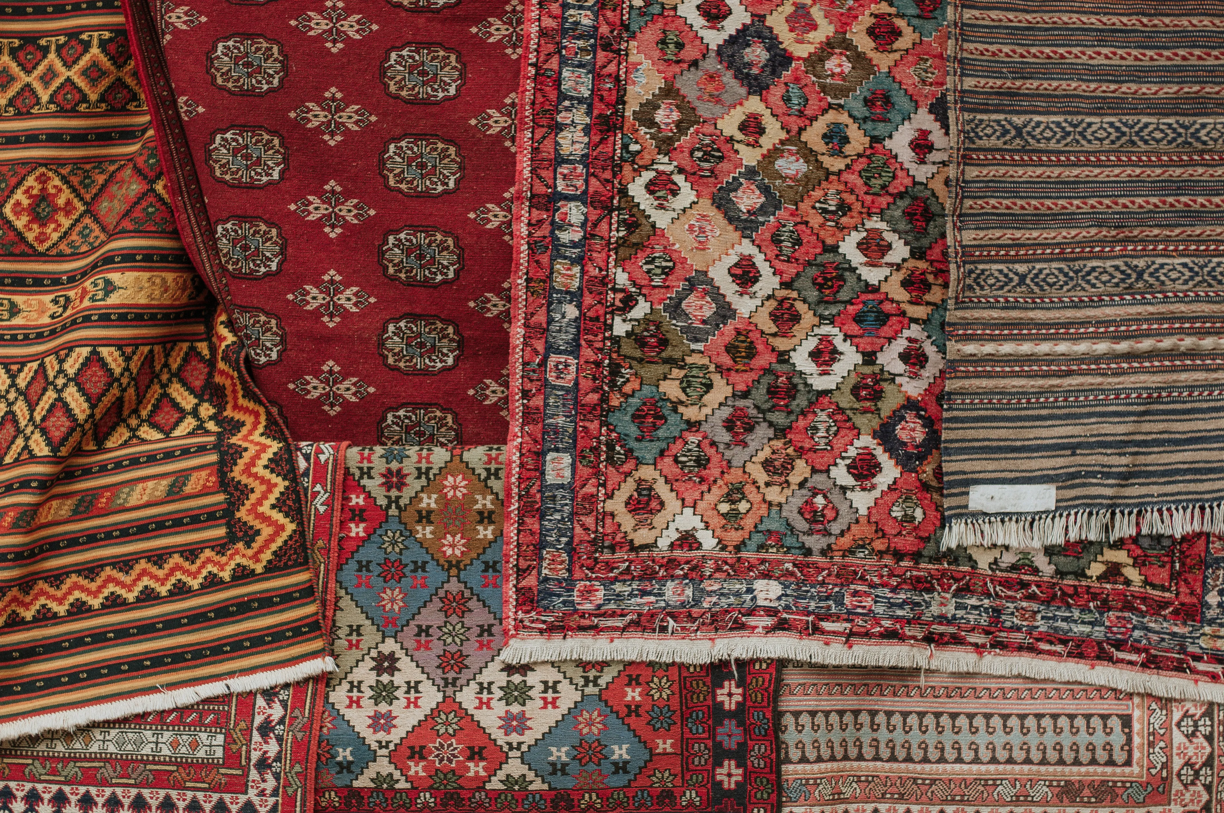 A collection of rugs in a variety of colors, designs, and sizes.