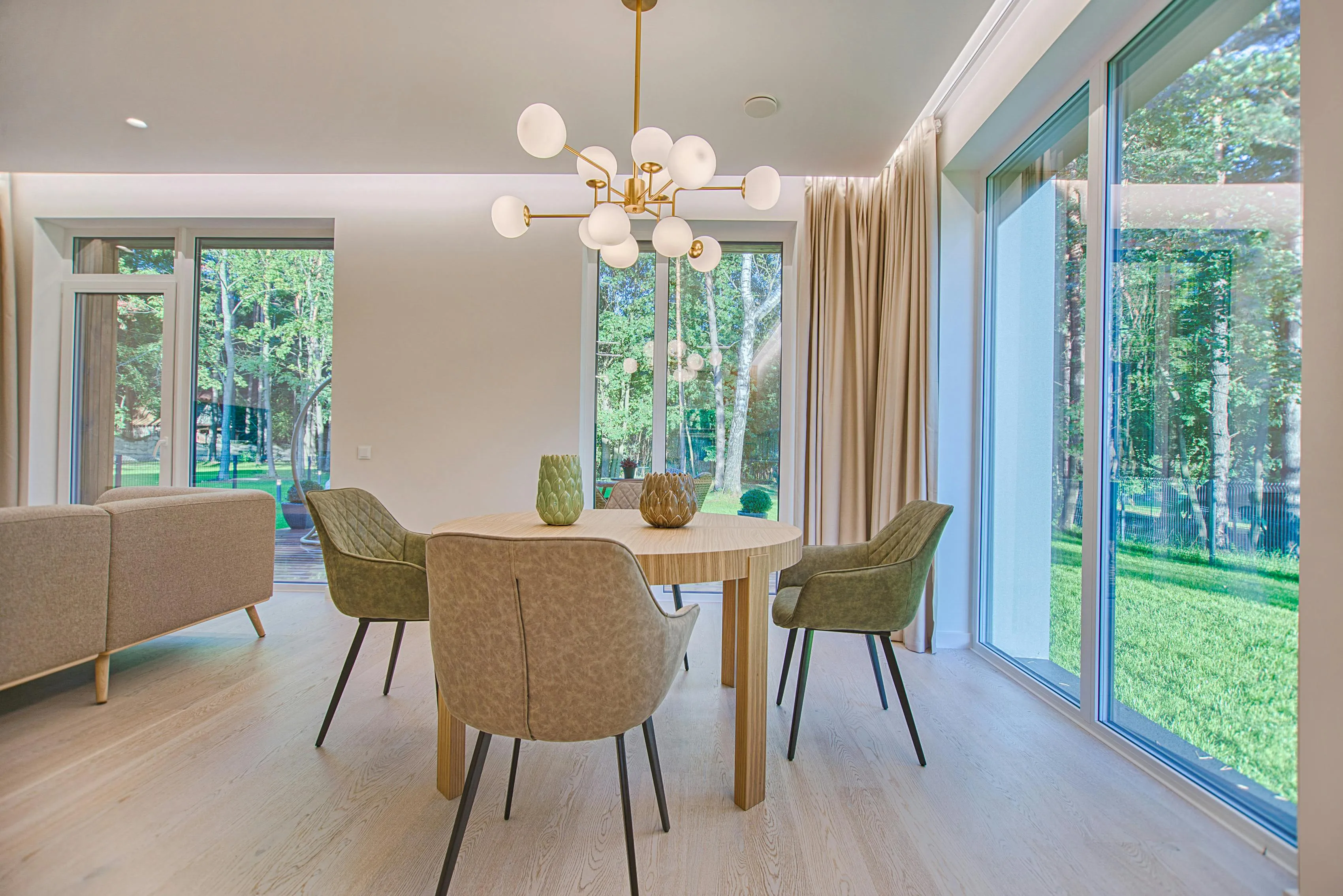 A round wooden dining table along with four chairs. There's hanging light there.