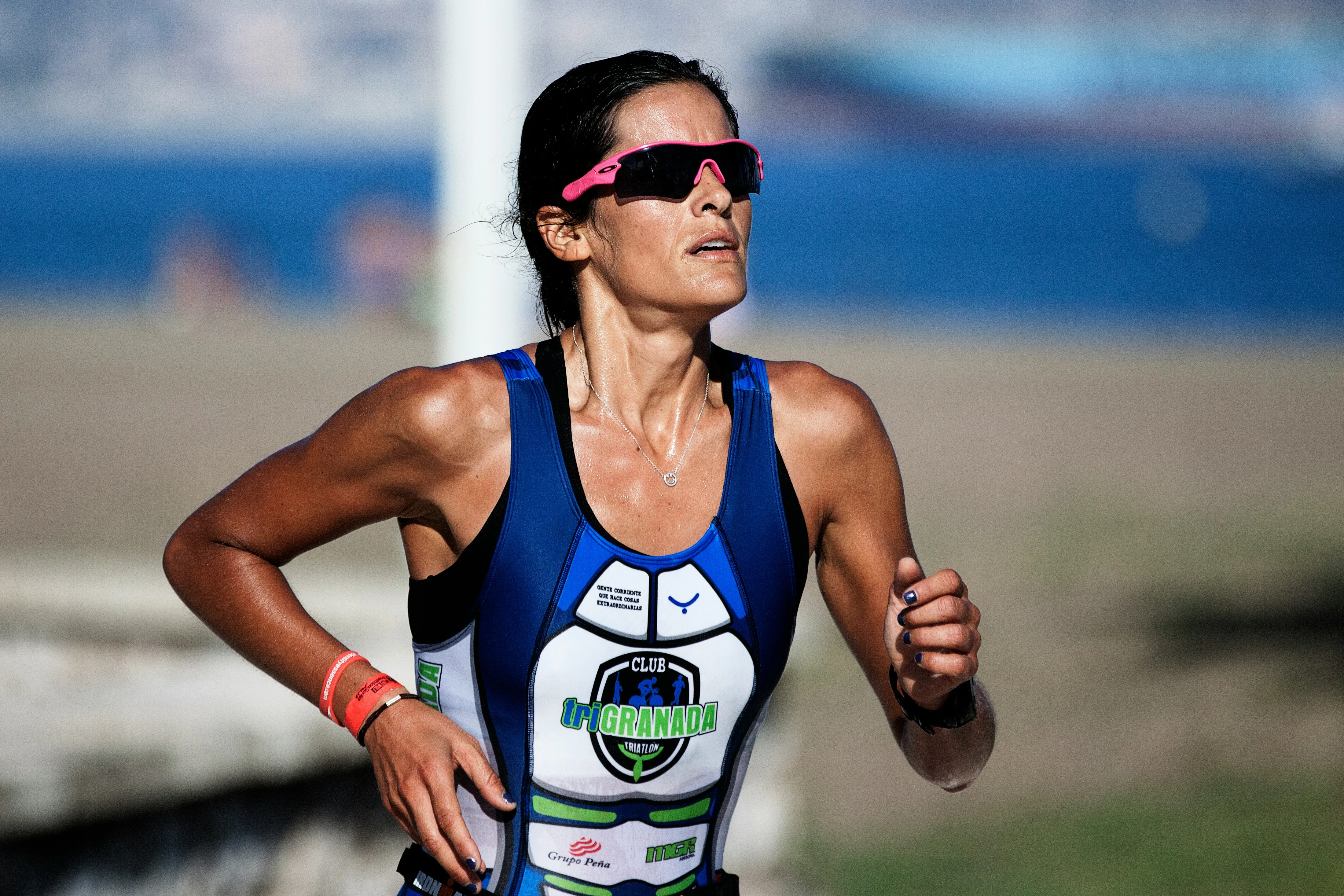 A runner wearing a pink sports sunglass while running.