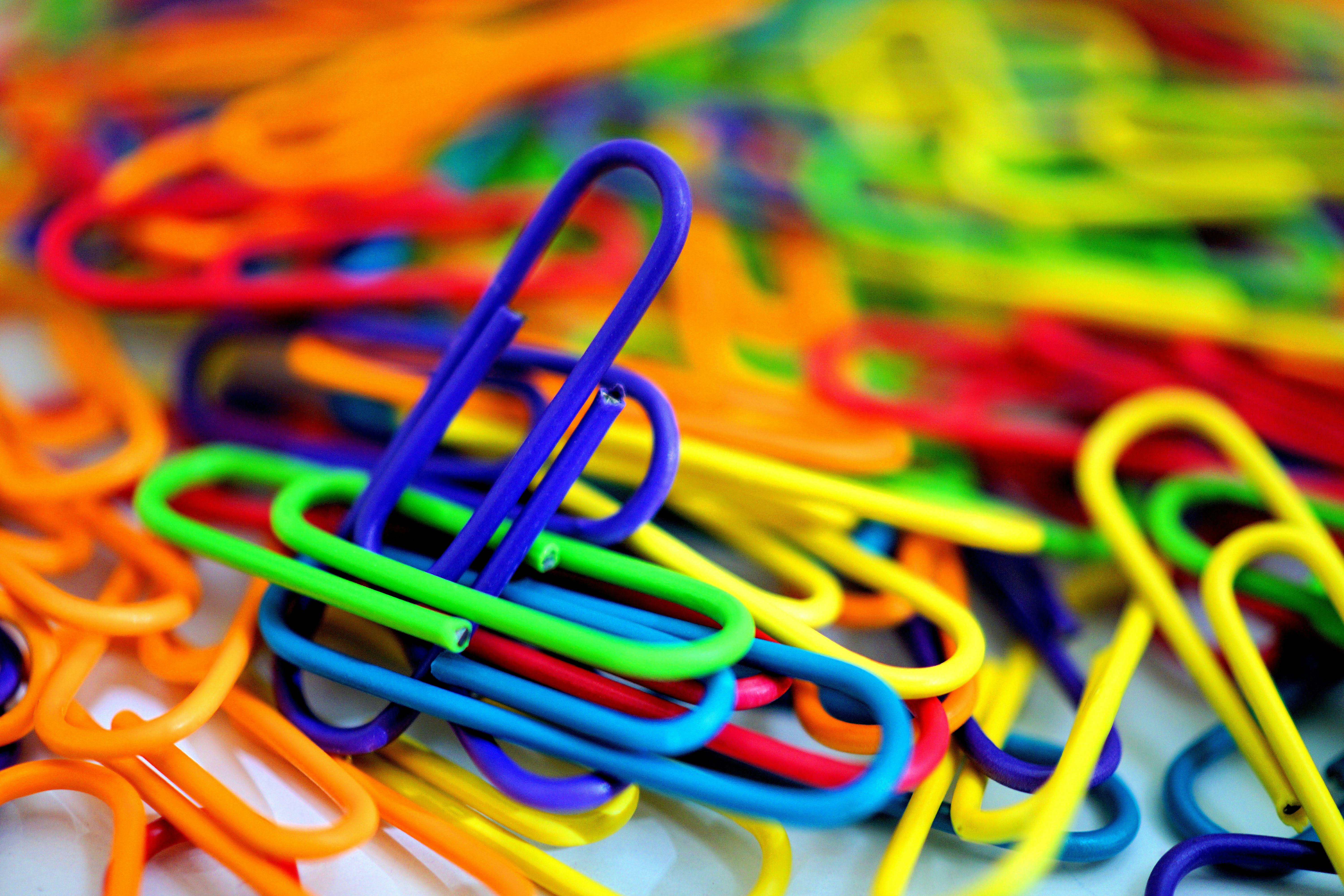 A pile of different colored paperclips