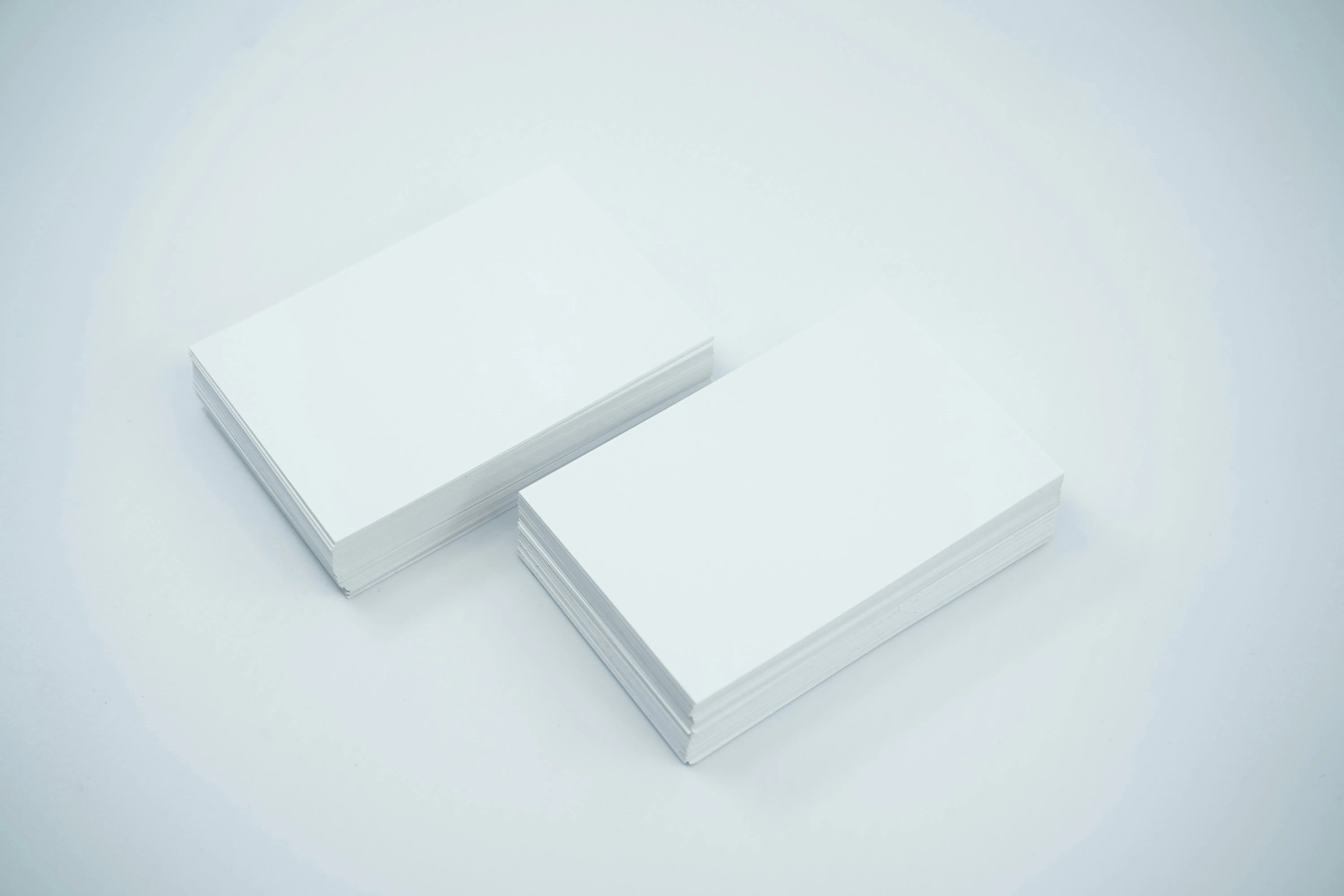 two stacks of a4 size paper on a white background.