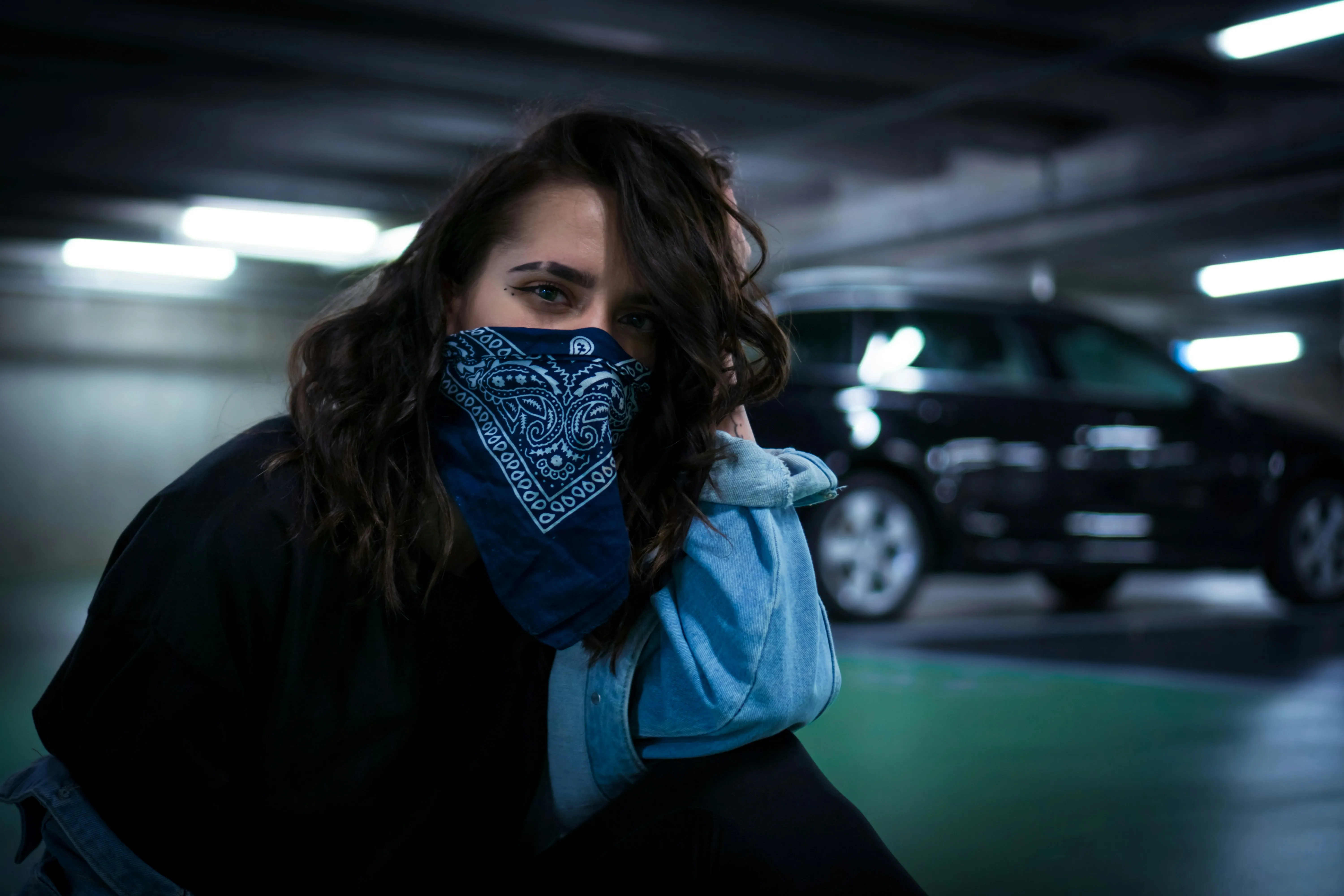 Woman sitting with a bandana on her face